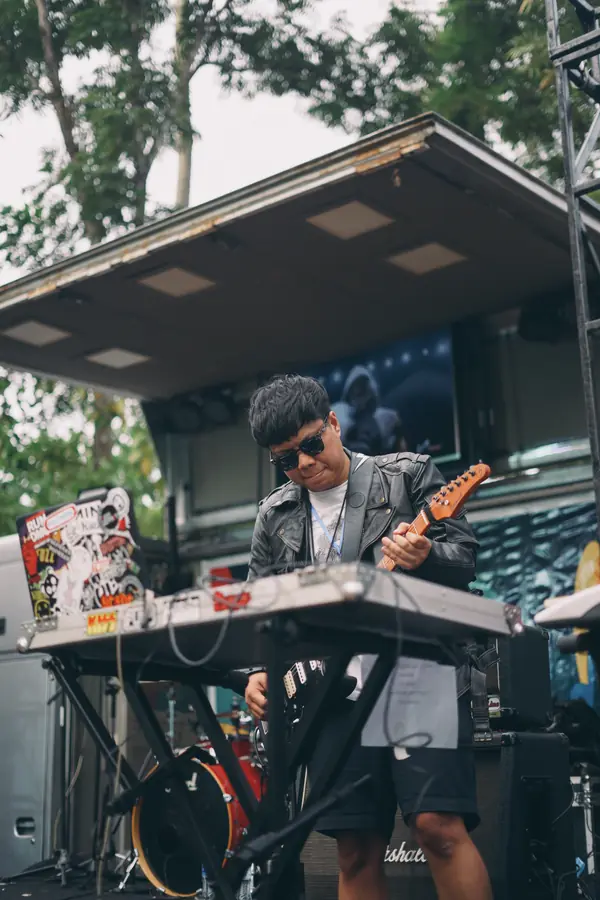 Welige with guitar and keyboard on an outdoor stage