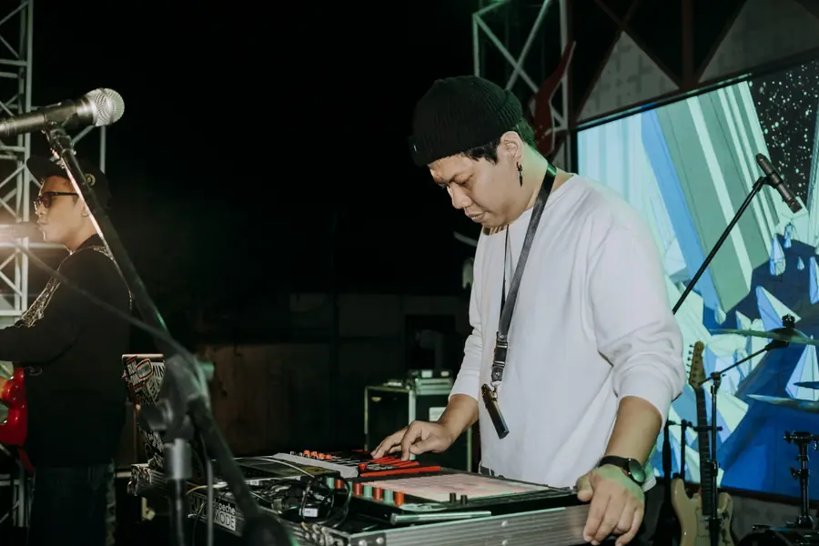 Welige playing keys on an open-air stage at night